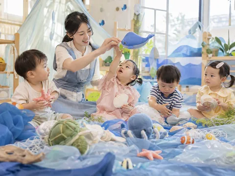 푸른 천과 바다 동물 인형, 조개 소품으로 상상놀이를 하는 아이들의 AI 연출 이미지